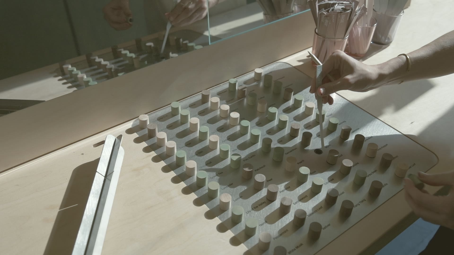 The note-sample tray set into the Fragrance Studio’s plywood bench, pots of scent strips beside it