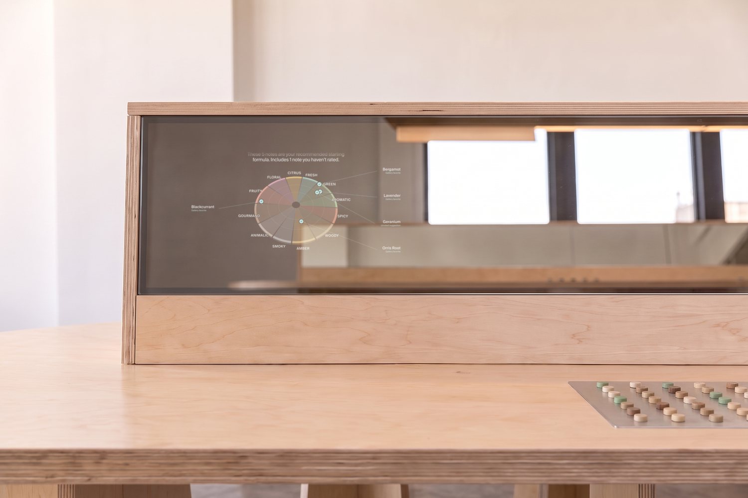 A workstation’s mirror screen showing a guest’s scent wheel and recommended starting formula