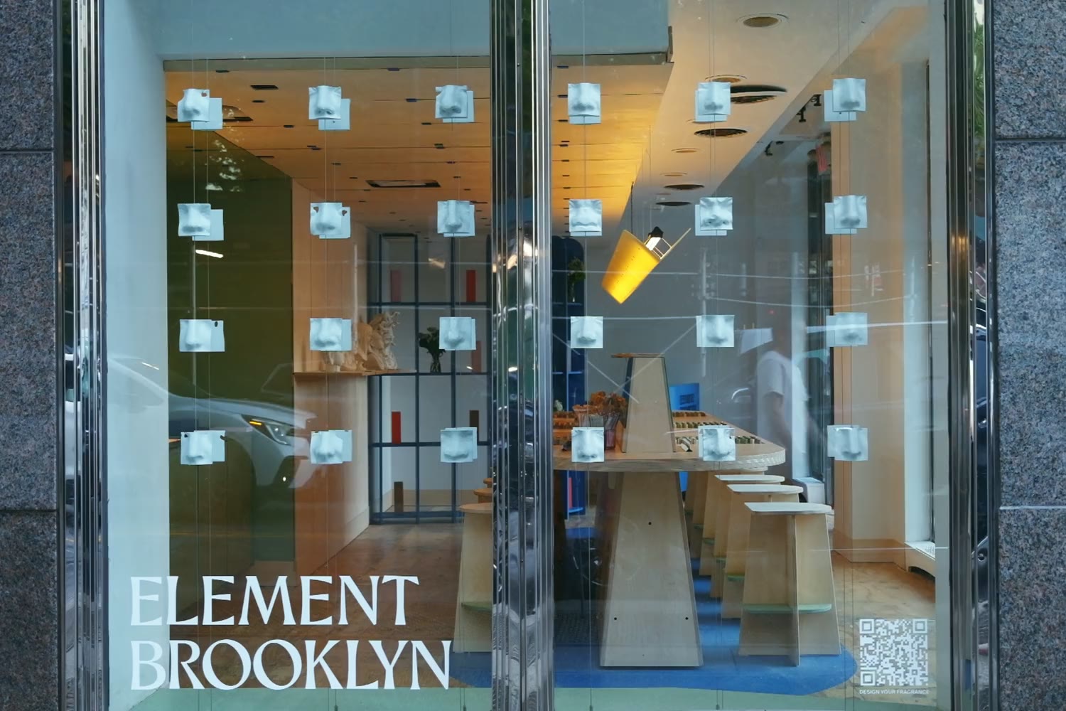 The Fragrance Studio’s window on Front Street, its rows of plaster noses and the studio bench behind the glass, as people walk past