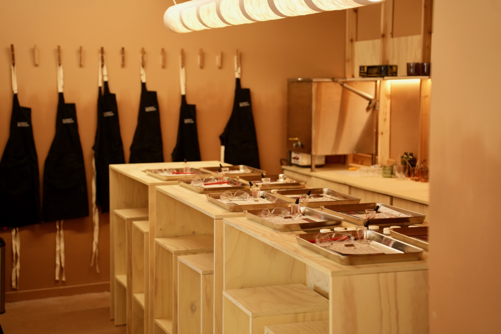 The workshop studio set for a session — aprons on the wall, trays on the bench